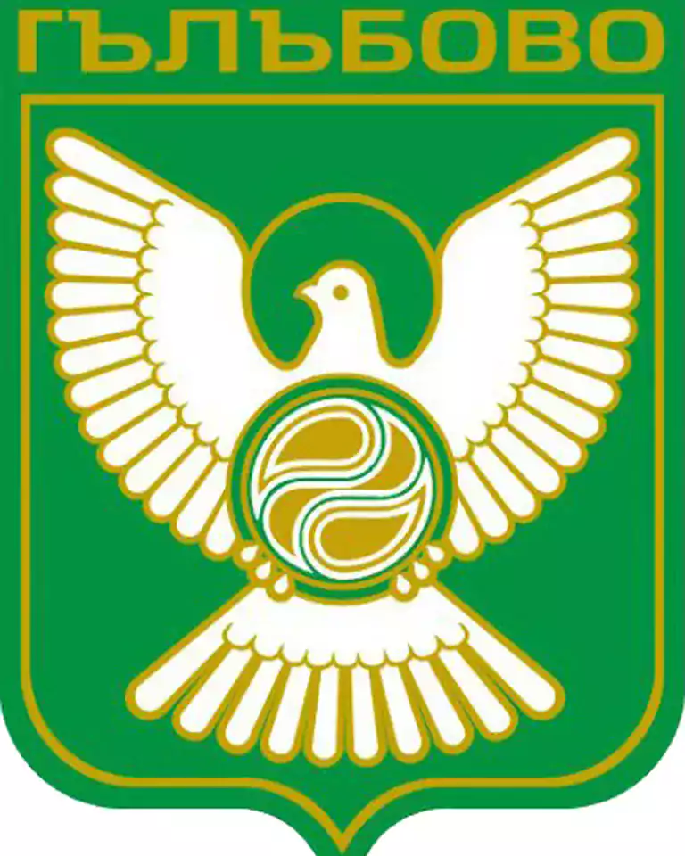 Green and gold emblem featuring a stylized white bird with outstretched wings, holding a circular symbol on its chest. The emblem is bordered in gold, and the Cyrillic word 'Гълъбово' appears at the top.
